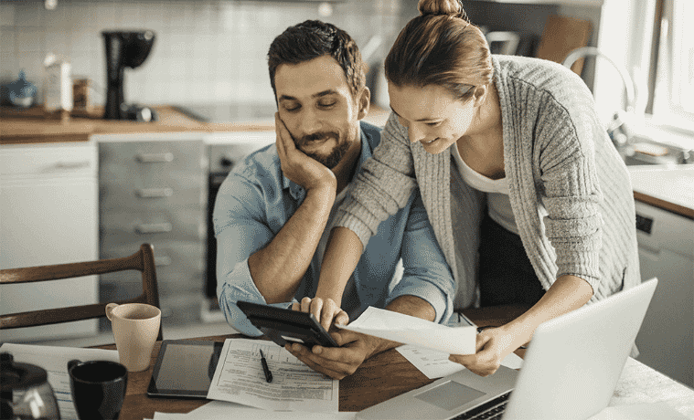 A husband and wife go over the floor plans of their kitchen renovation