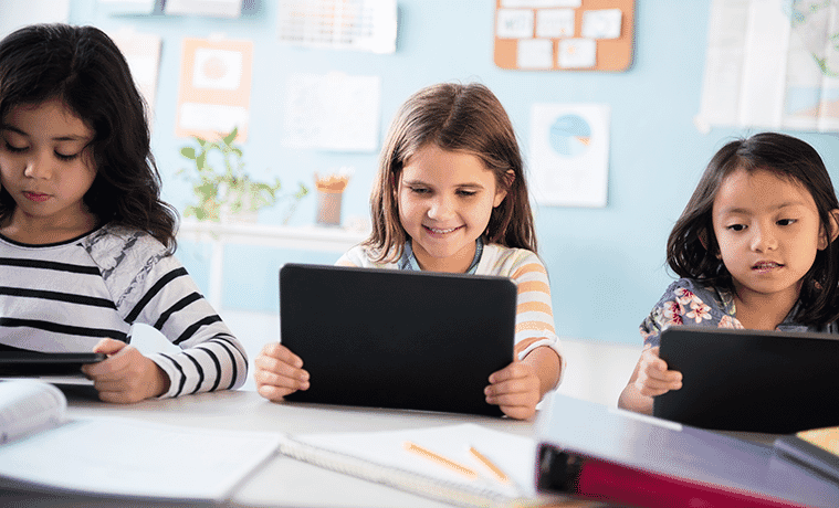Group of children learning on their tablets at school