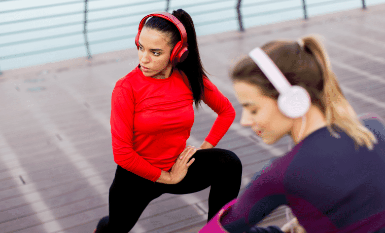 two girls getting ready for a run outside while they wear noise cancelling headphones