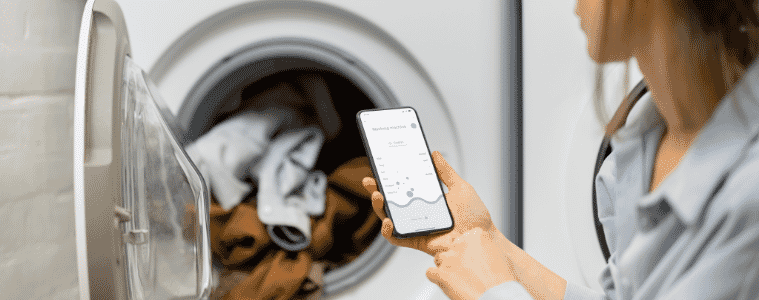 Woman controls her WiFi connected washing machine using a smartphone