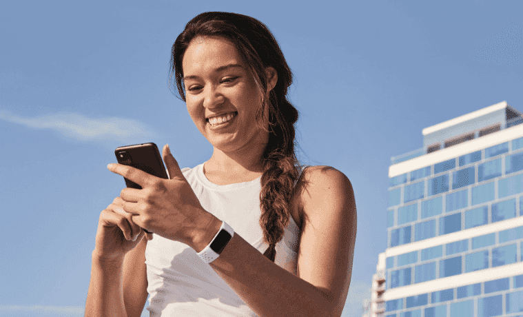 Young female athlete looking at her activity tracker during training