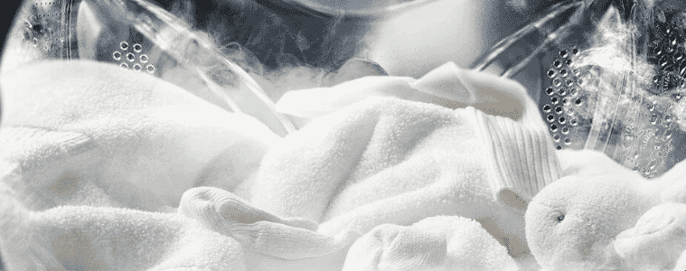 White clothing is in the process of drying inside a dryer