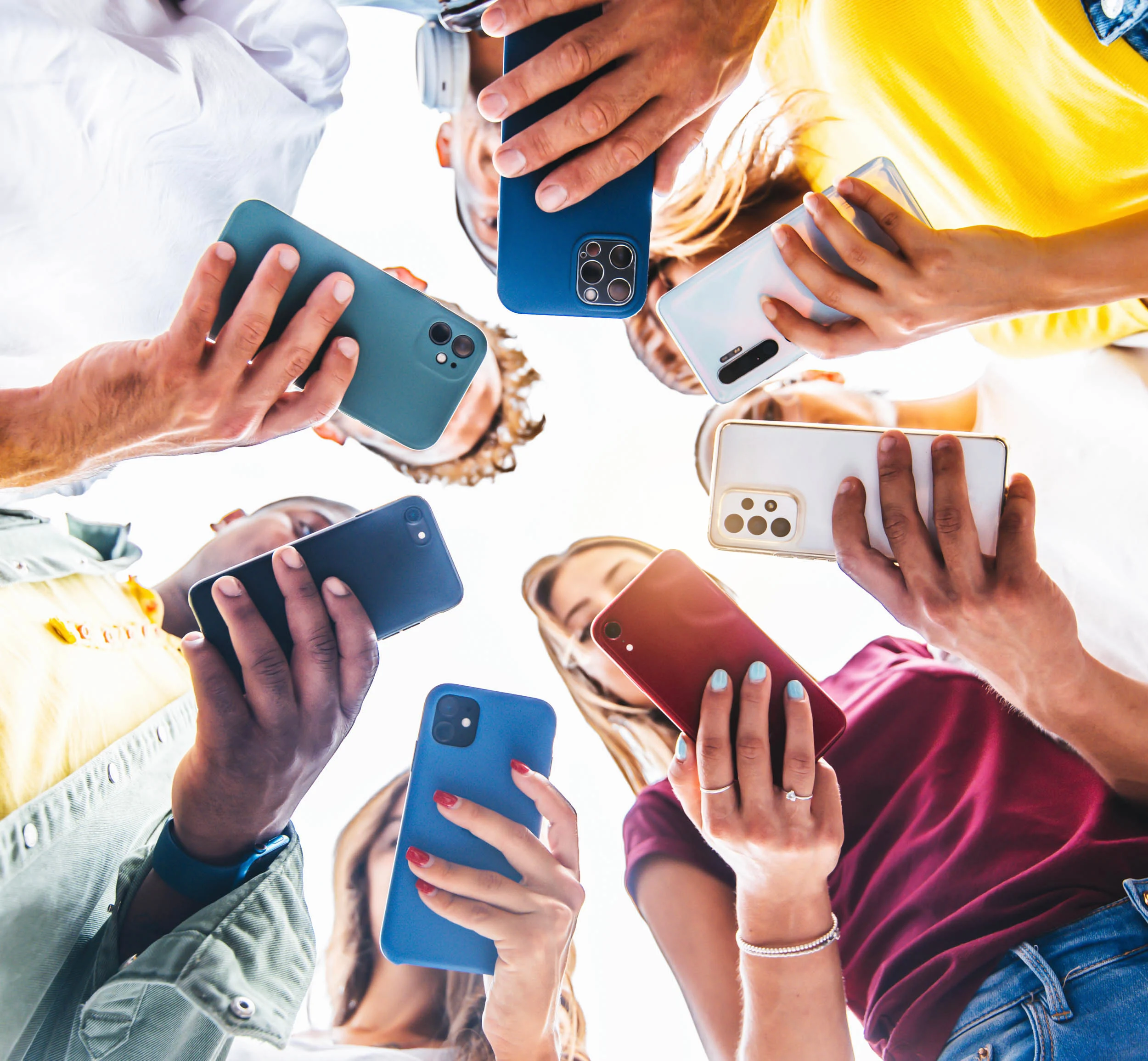 A group of people using their smart phones whilst outside together