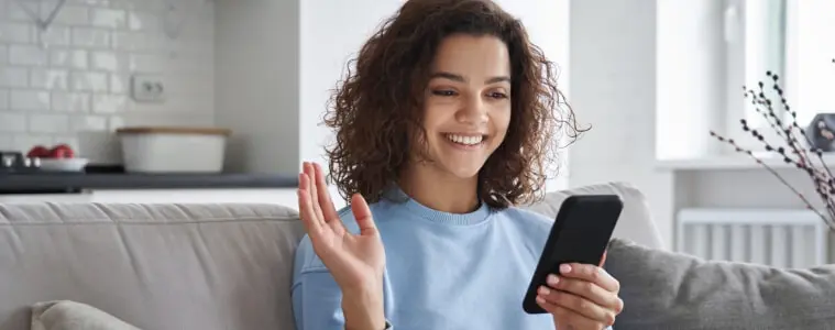 A young person plays on a smartphone with their parent