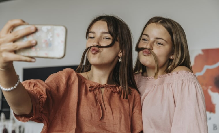 Two girls taking a photo with a mobile phone