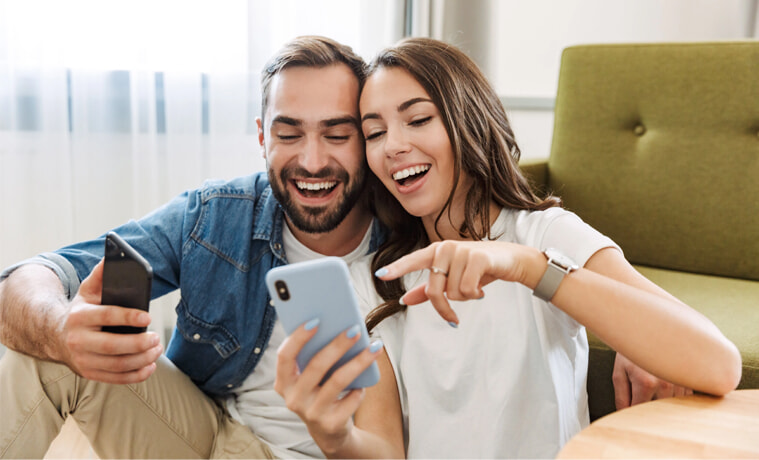 A man and woman use their phones together
