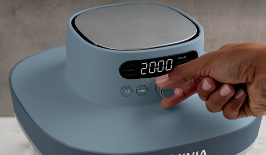 Close-up image of a woman turning the temperature dial on a Ninja Crispi Pro Air Fryer