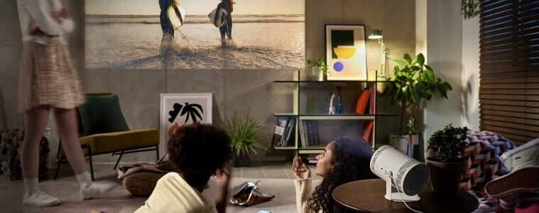 3 friends watch a movie on a projector in their living room