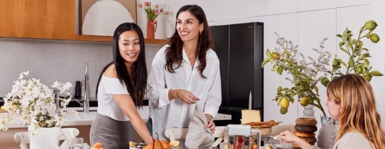 A group of friends sit down to enjoy a meal prepared from the Samsung French door fridge