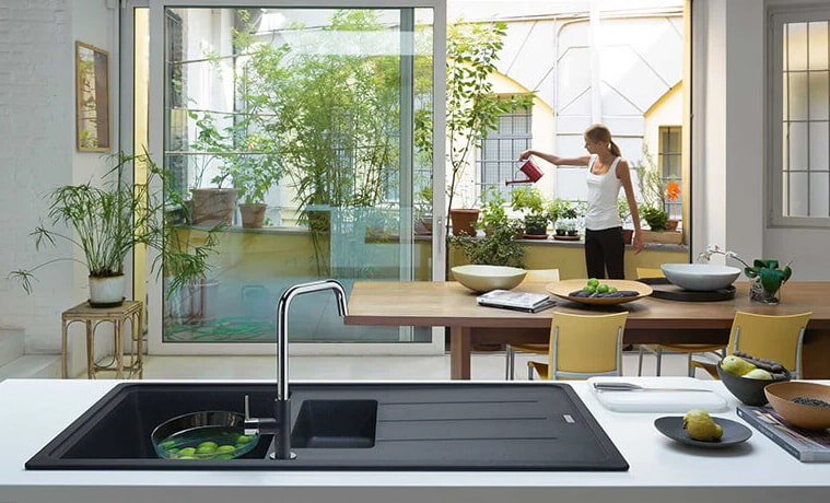 A matt black kitchen sink with fruit soaking in a bowl