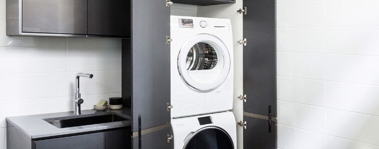 A stacked washer and dryer in a small laundry