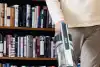 Man using Shark stick vacuum to vacuum living room effortlessly.