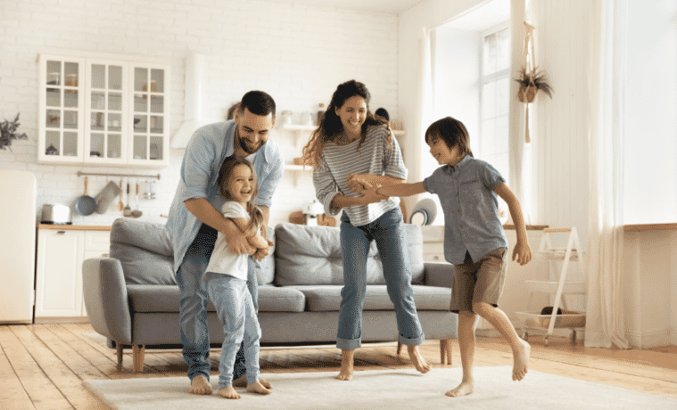 Happy family playing funny game having fun together with little son and daughter in modern living room