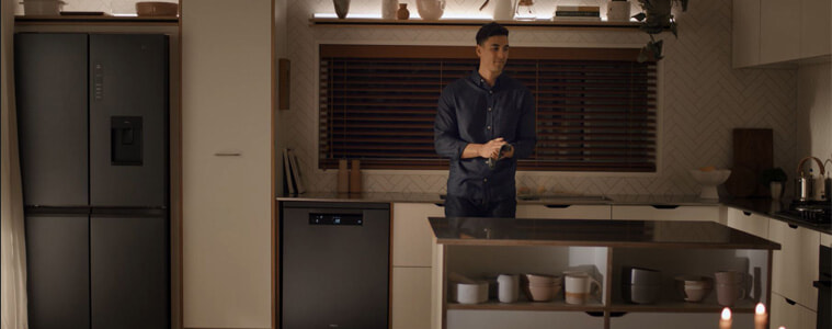 A cleans up after dinner with the help of the Haier Dishwasher Satina