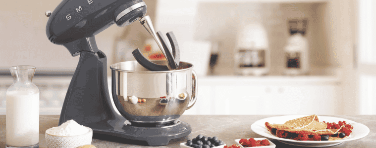 Image of the Smeg 50s Style Stand Mixer on a kitchen bench with a plate of crepes and ingredients