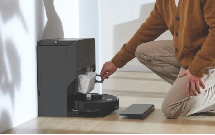 Person removing the dust bag from a roborock vacuum auto-empty station
