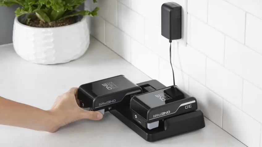 A person puts their Hoover ONEPWR battery on charge in their laundry