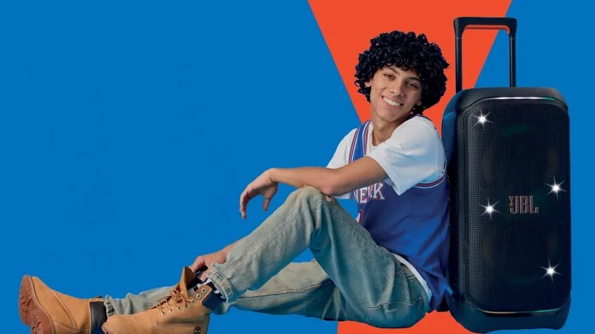 man leans against JBL partybox