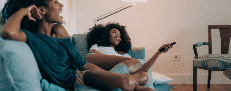Two people watching TV on their couch