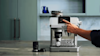 Man pressing button on his De'Longhi Coffee Machine.