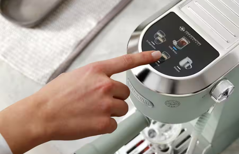 Woman pressing button on his De'Longhi Coffee Machine.