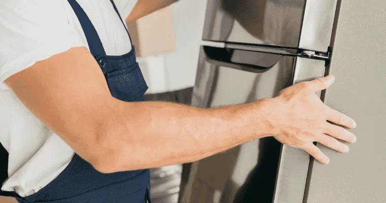 Close up of a man moving a fridge.