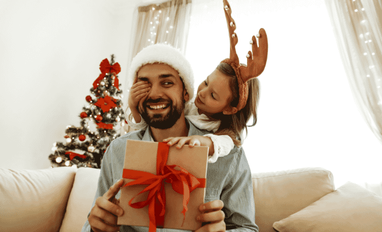 Little girl surprises her dad on Christmas morning with a beautifully wrapped gift