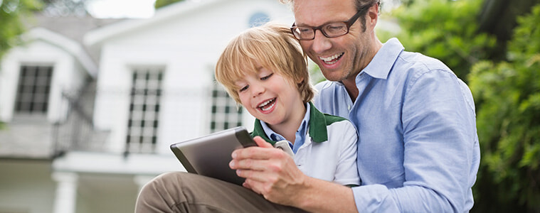 Father and young son using a digital tablet outdoors