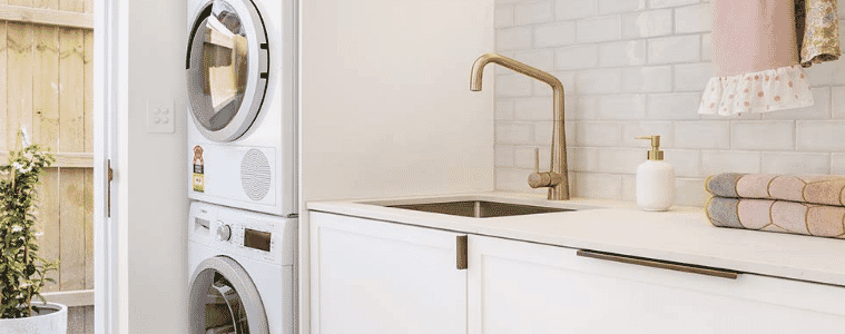 A white clean laundry with a heat pump dryer on top of a washing machine