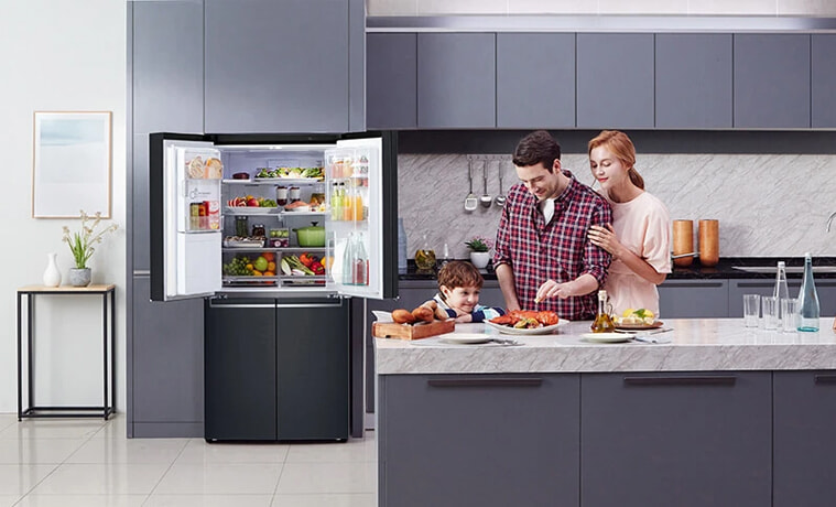Two parents prepare food for their young son in the kitchen