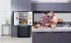 Two parents prepare food for their young son in the kitchen