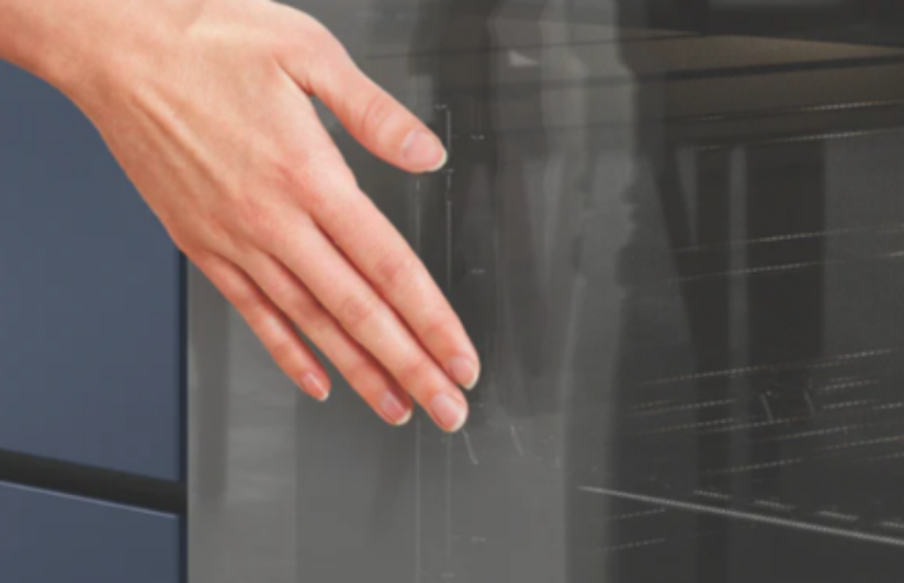 Close-up image of the Westinghouse oven with woman touching the door. 