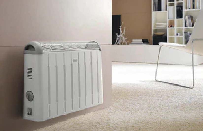 White electric panel heater mounted on a bedroom wall with a freestanding mirror nearby
