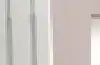 White electric panel heater mounted on a bedroom wall with a freestanding mirror nearby