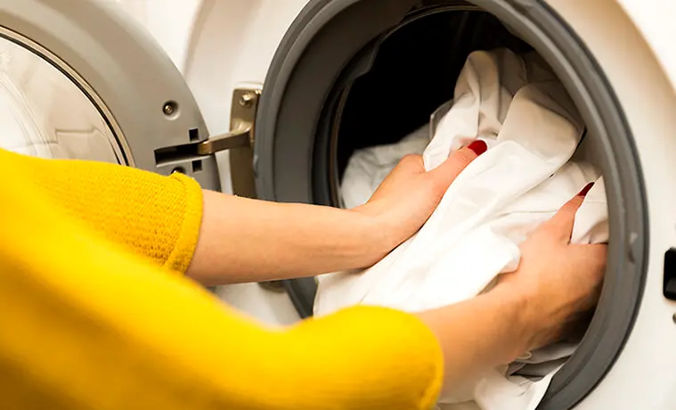 Woman loading white clothes into a washing machine