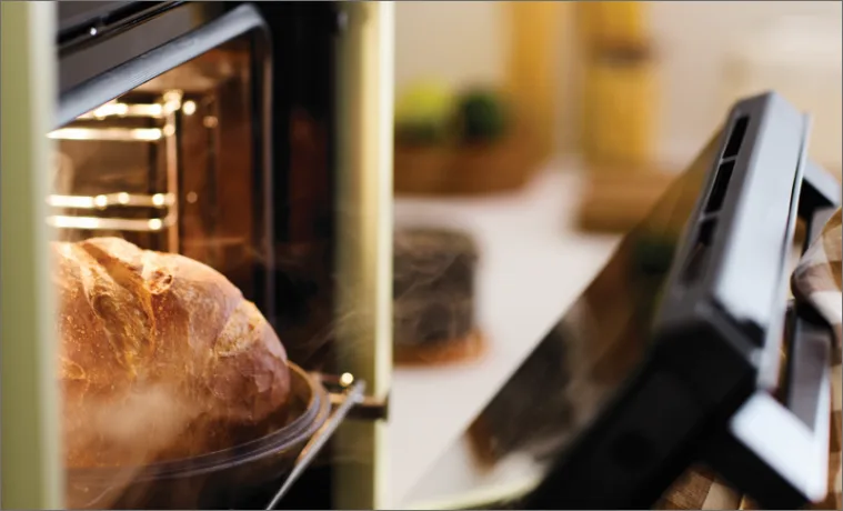 a mid grey Haier oven in a green kitchen