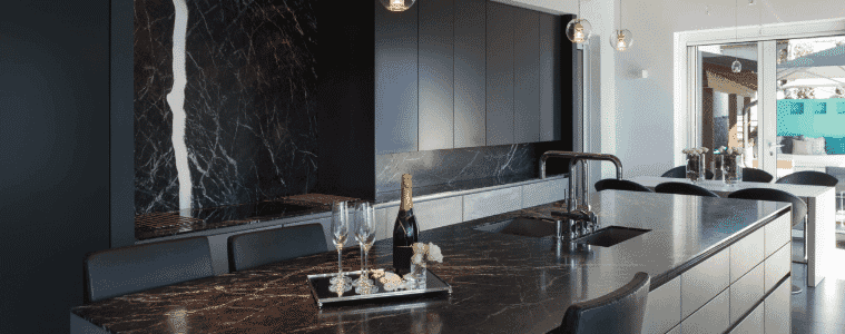 A dark and moody kitchen with an attached dining table