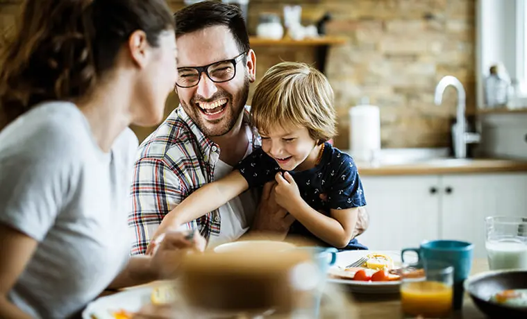 Cheerful family having fun during their meal at the dining table