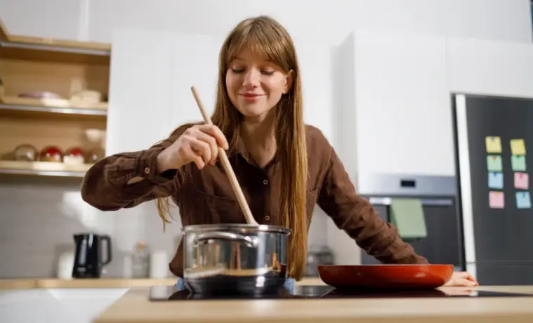Woman cooking on Induction Cooktop at home. 