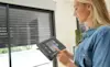 A person viewing controlling their home security via a tablet