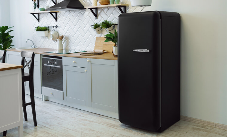 A black fridge in a white modern kitchen