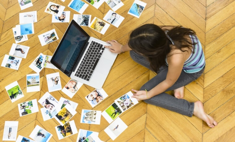 A young girl sorts and prints pictures from her holidays