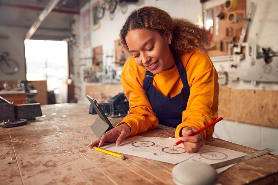 A woman works in her workshop while using a Google Nest smart speaker