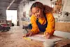 A woman works in her workshop while using a Google Nest smart speaker