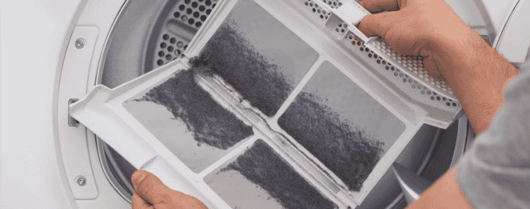 A person clears the lint from the lint filter