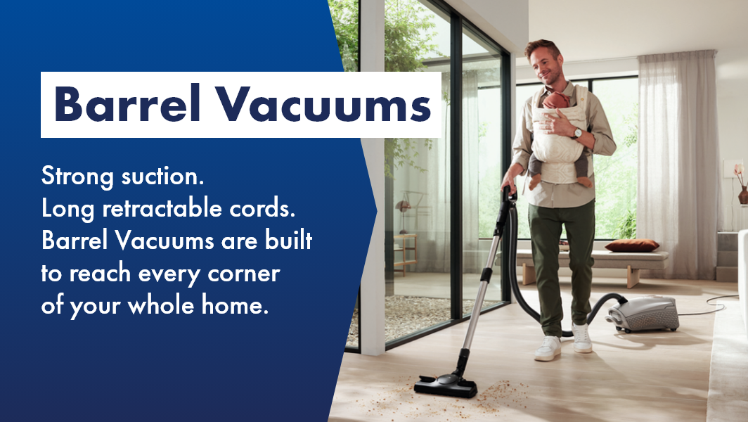 Man using barrel vacuum to clean his living room with child, shop Barrel Vacuums now at The Good Guys!
