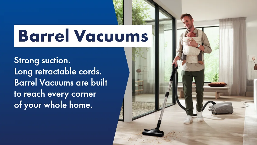 Man using barrel vacuum to clean his living room with child, shop Barrel Vacuums now at The Good Guys!