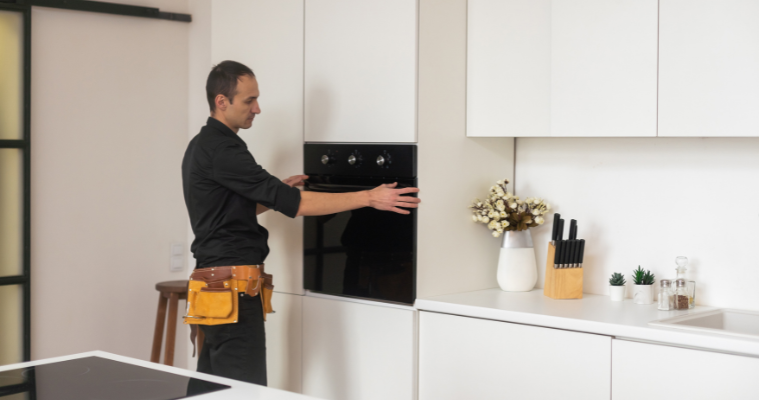 Man installing an oven in modern kitchen with ease. 