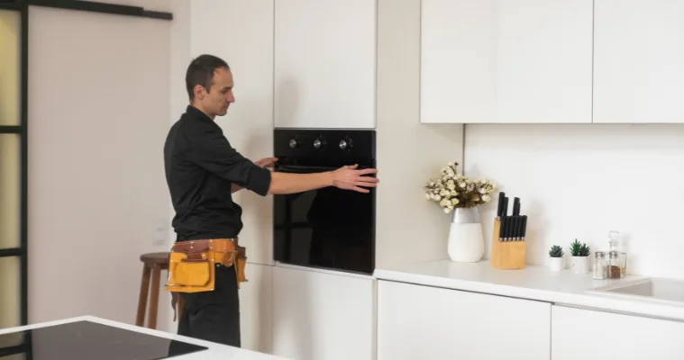 Man installing an oven in modern kitchen with ease.