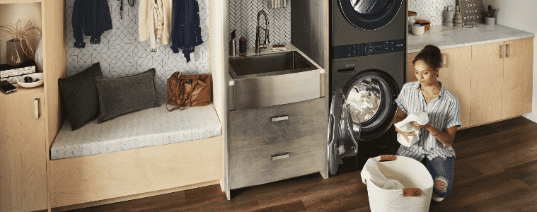 Woman loading her basket of washing into an LG WashTower in her modern laundry 